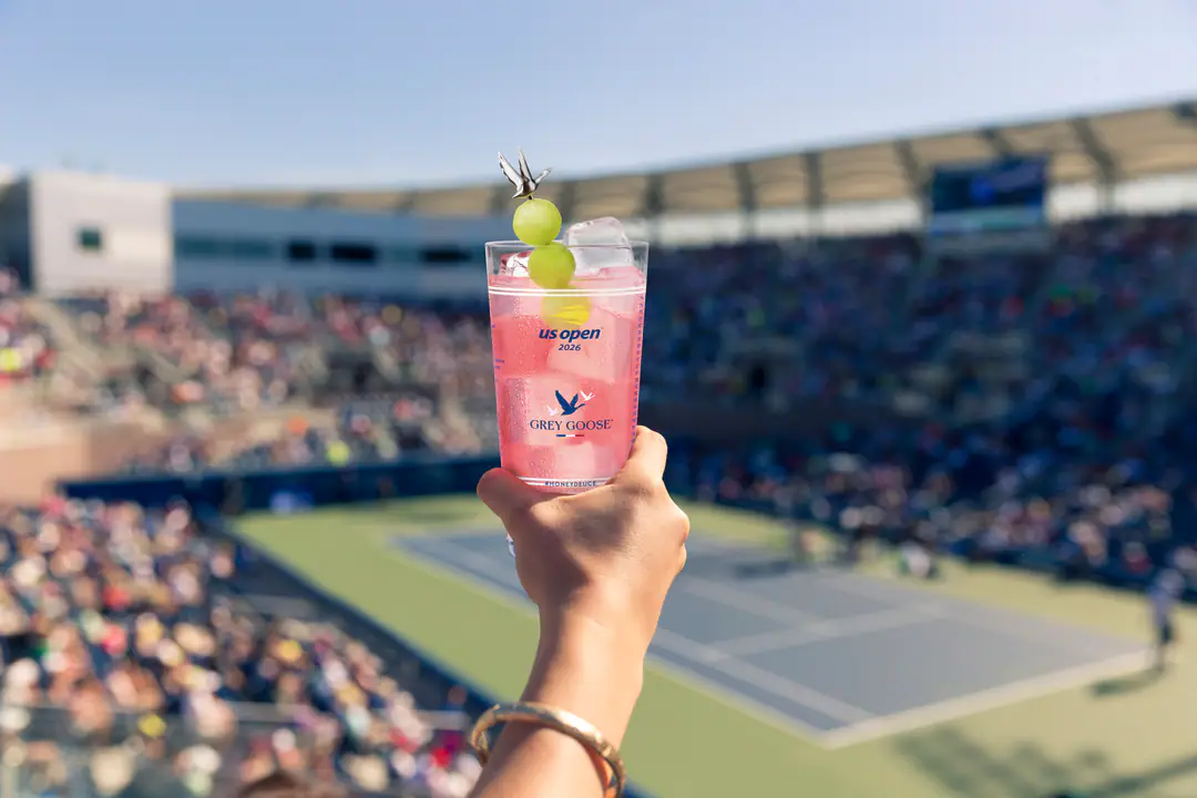 Grey Goose Honey Deuce in the official US Open 2026 cup with the tennis court visible behind it